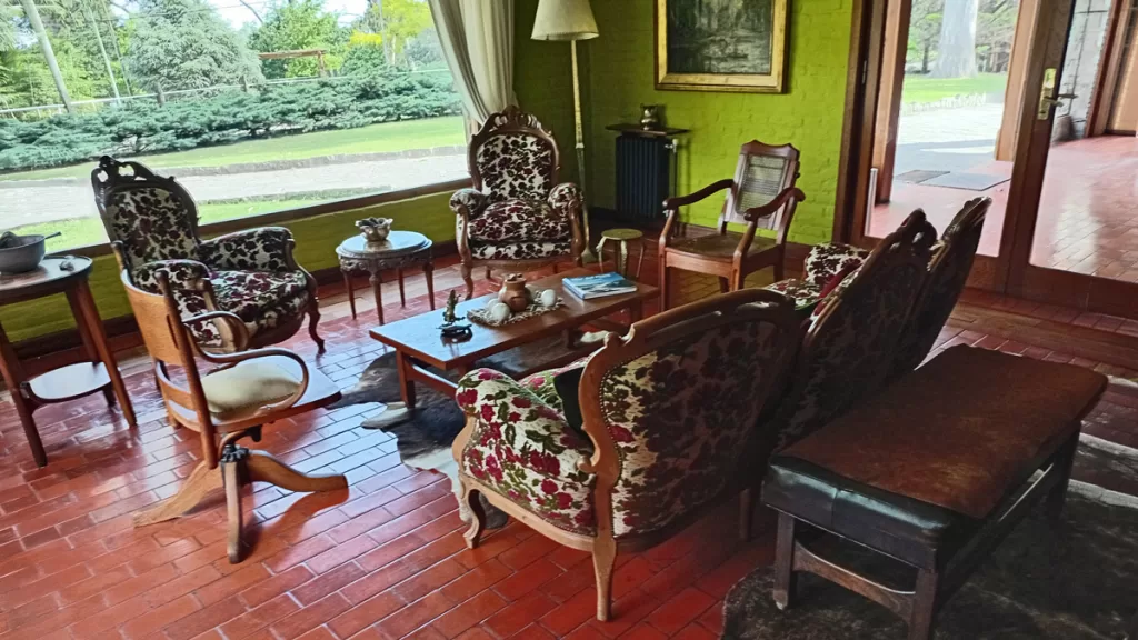 Sillones antiguos y ventanales al jardín en el estar de Los Nobles Art