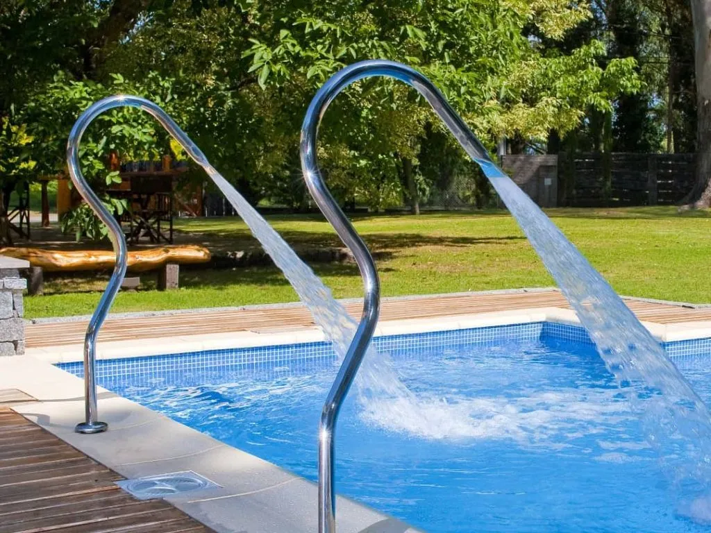 El parque de Los Nobles Art, con piscina exterior y árboles